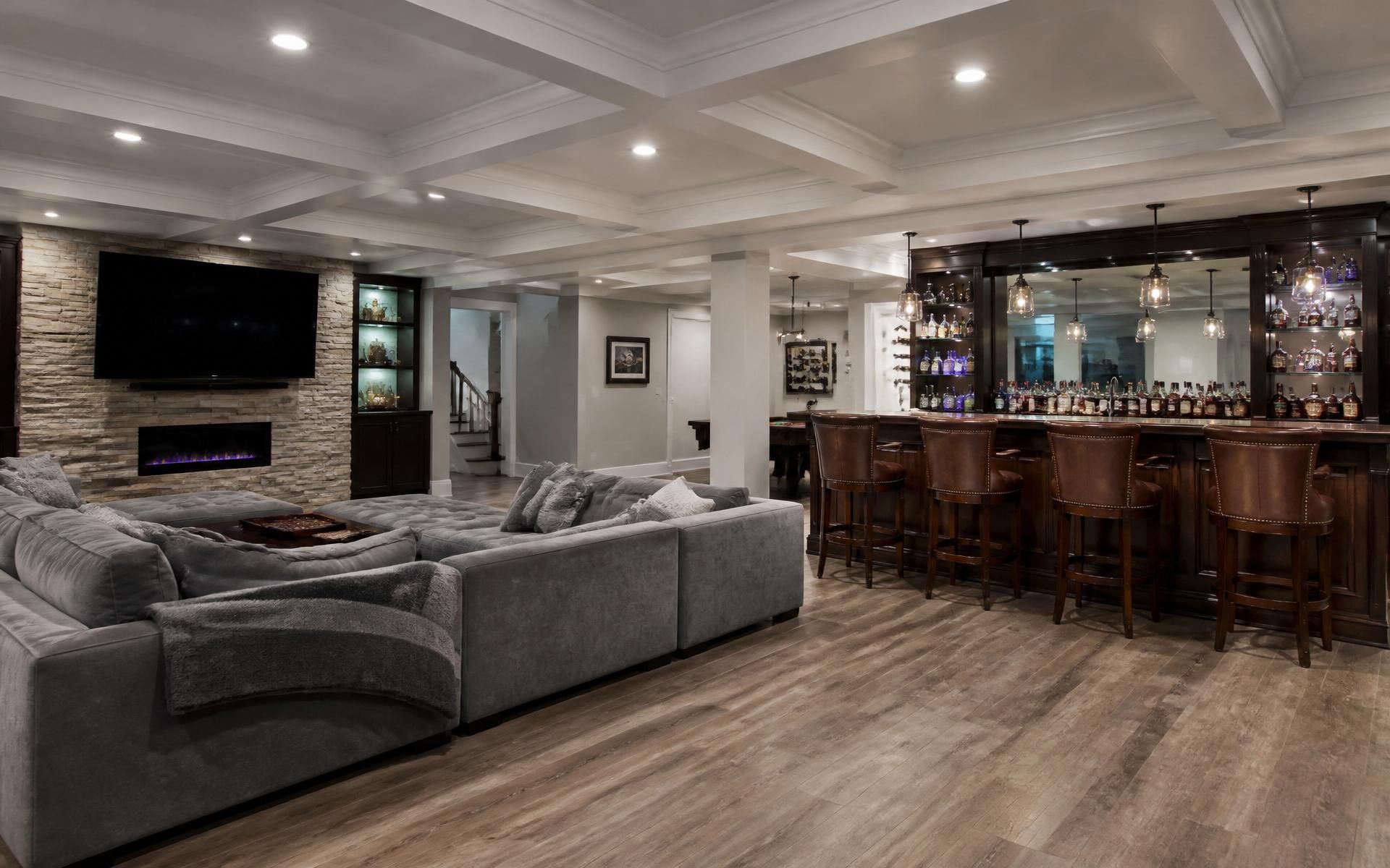 Beautifully remodeled basement featuring a sectional and pub-style bar